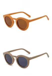 Detail view of round retro sunglasses in bright orange and matte taupe frames