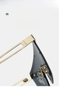 Detail of gold metal sunglasses frame with geometric hollow temples and grey lenses