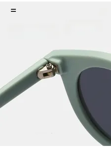 Detail view of durable metal hinge on mint green retro sunglasses with dark grey lenses
