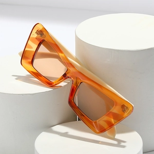 Lunettes de soleil papillon rétro ambre sur socles géométriques avec ombres nettes