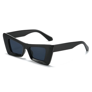 Lunettes de soleil œil de chat rétro noires avec monture épaisse et verres fumés foncés de profil