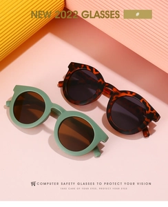 Close-up of stylish round frame kids sunglasses in tortoiseshell and morandi green