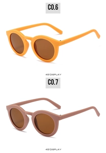 Detail view of round children's sunglasses in bright orange and dusty pink frames