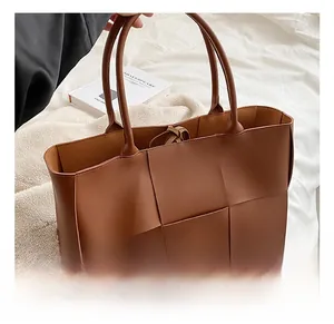 Detail showing high-quality broad weaving texture and interior ties of a brown tote bag