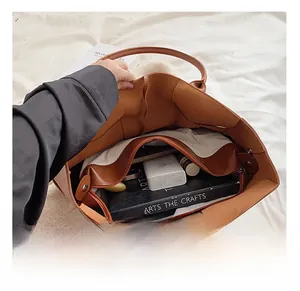 Top view of large capacity brown tote bag interior with a zipper pocket and daily essentials