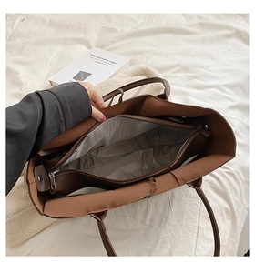 Detail view of large brown woven tote bag interior with gray lining and zipper