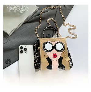 Gros plan du sac boîte doré avec illustration pop art et poignée en foulard de soie