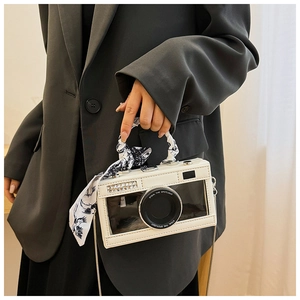 Detail of camera-shaped bag with white leather texture, clear window, and silk scarf wrap