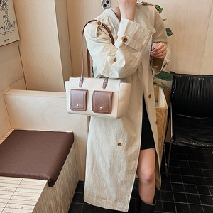 Detail of contrast color crossbody bag showing brown front pockets and metal buckle
