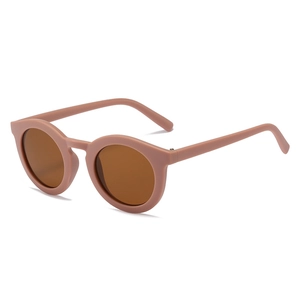 Classic round matte pink kids sunglasses with dark brown lenses on white background
