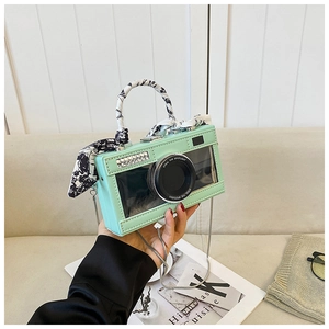 Detail of mint green camera bag with transparent lens window and silk handle wrap