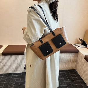 Detail of vintage contrast shoulder bag featuring dual front pockets and silver buckles