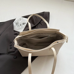 Internal view of a spacious beige leather tote bag with zip pocket and fabric lining