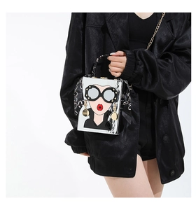 Détail du sac boîte miroir argenté avec visage artistique et poignée foulard