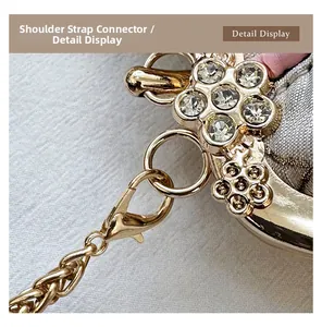 Macro shot of gold floral shoulder strap buckle with crystals on grey embroidered bag