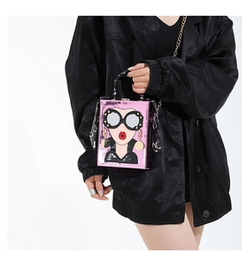 Détail du sac boîte rose avec motif visage de dessin animé et anse en foulard de soie