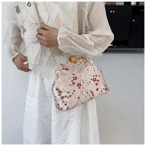 Detail of red plum blossom embroidery and pearl clasp on the vintage cheongsam bag
