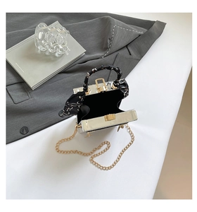 Vue détaillée du sac boîte argenté avec chaîne dorée et foulard en soie au manche