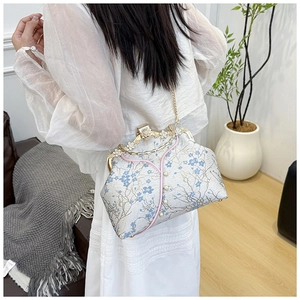 Detail of floral embroidery on a vintage frame bag with pearl and rhinestone closure