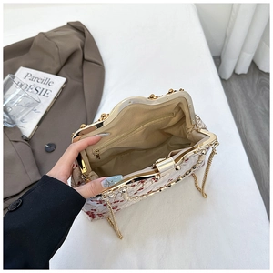Internal view of a vintage floral embroidery handbag with metallic gold frame and chain strap