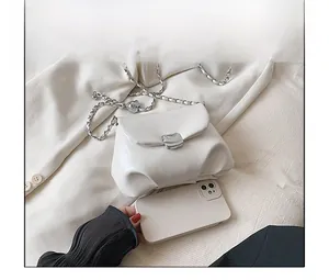 Dettaglio borsa a tracolla bianca con catena d'argento e telefono per confronto dimensioni
