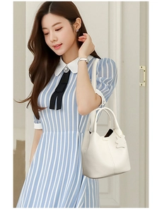 Detail of white lychee pattern leather bucket bag with cute bear charm and shoulder strap