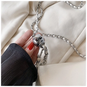 Dettaglio catena in argento con fibbia a sfera strutturata su borsa bianco crema