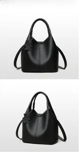 Macro shot of the black lychee pattern leather bucket bag with top handle and bear charm