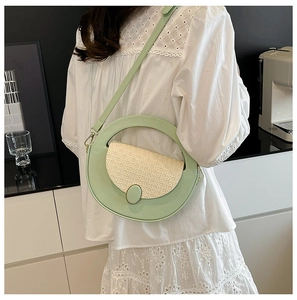 Detail of round light green handbag featuring beige woven texture and leather strap