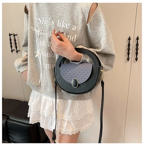 Close-up of the vintage round crossbody bag with woven texture and gold metal buckle