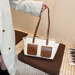 Contrast color tote bag with front pockets and brown straps for a retro minimalist look