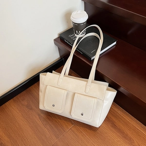 Chic cream-colored crossbody tote bag with rivet accents and stylish flap pockets