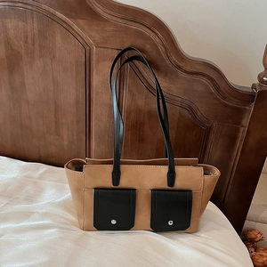 Retro tan faux leather tote bag with black shoulder straps and dual front pockets