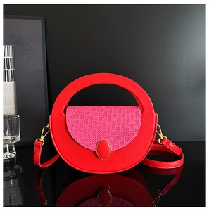 Detail of red circular handbag with pink woven texture and gold gemstone buckle