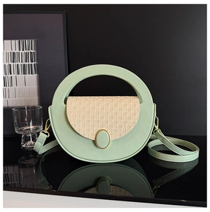 Detail of light green leather bag with cream woven panel and gold metal lock