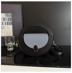 Detail of round handle handbag with woven blue-grey flap and gold metal buckle