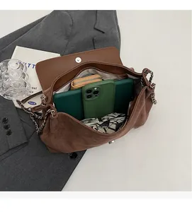 Dettaglio interno della borsa a spalla in pelle scamosciata con ampia capienza e zip