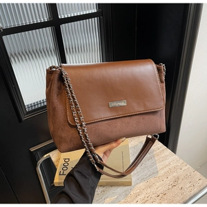 Detail der braunen Vintage Wildleder Umhängetasche mit Kette und YOUBER Metallplakette
