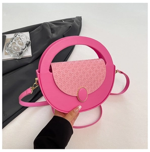 Detail of hot pink handbag featuring woven texture flap and golden oval metal buckle