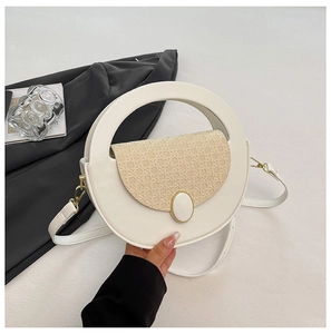 Detail of white leather crossbody bag with woven texture flap and round top handle