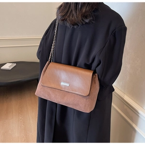 Dettaglio della borsa vintage con trama patchwork in pelle e camoscio di qualità