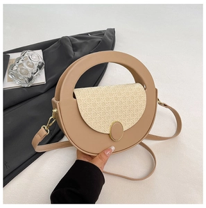 Detail of round handbag with woven fabric flap and leather handle for women