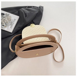 Detailed view of beige crossbody bag featuring woven texture flap and gold metal clasp