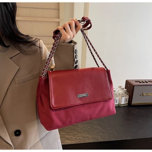Detail view of red leather and suede patchwork shoulder bag with silver chain strap