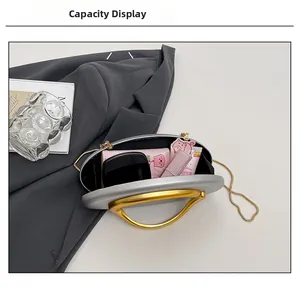 Silver oval clutch bag with gold ring handle showing interior capacity for essentials