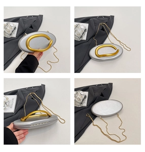 Detail views of silver metallic evening bag with sculptural gold C-handle and chain strap