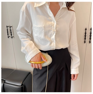 Detailed view of white long-sleeved shirt featuring delicate lace collar and chest pocket
