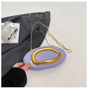 Close-up of lavender purple oval evening clutch featuring a bold gold U-shaped handle