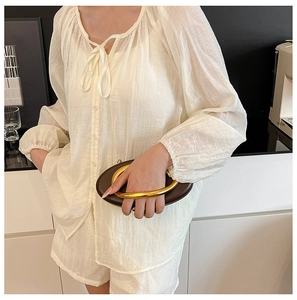 Detail of white two-piece lounge set featuring textured fabric and drawstring neckline