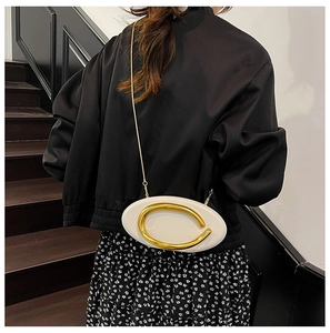 Chic off-white chain bag with gold C-buckle worn as a shoulder bag by a model